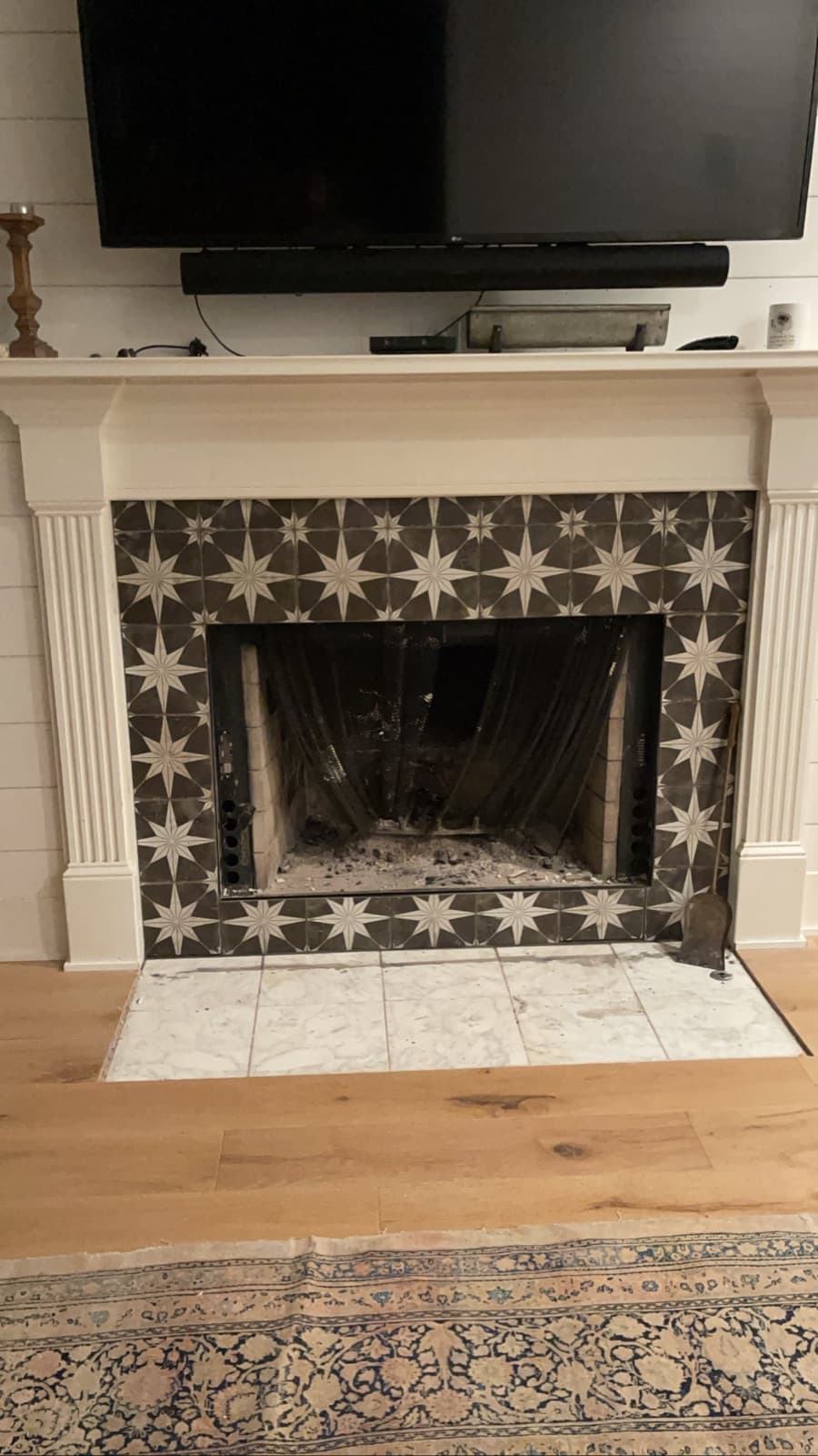 Star-pattern tile fireplace surround and marble hearth under a white mantel